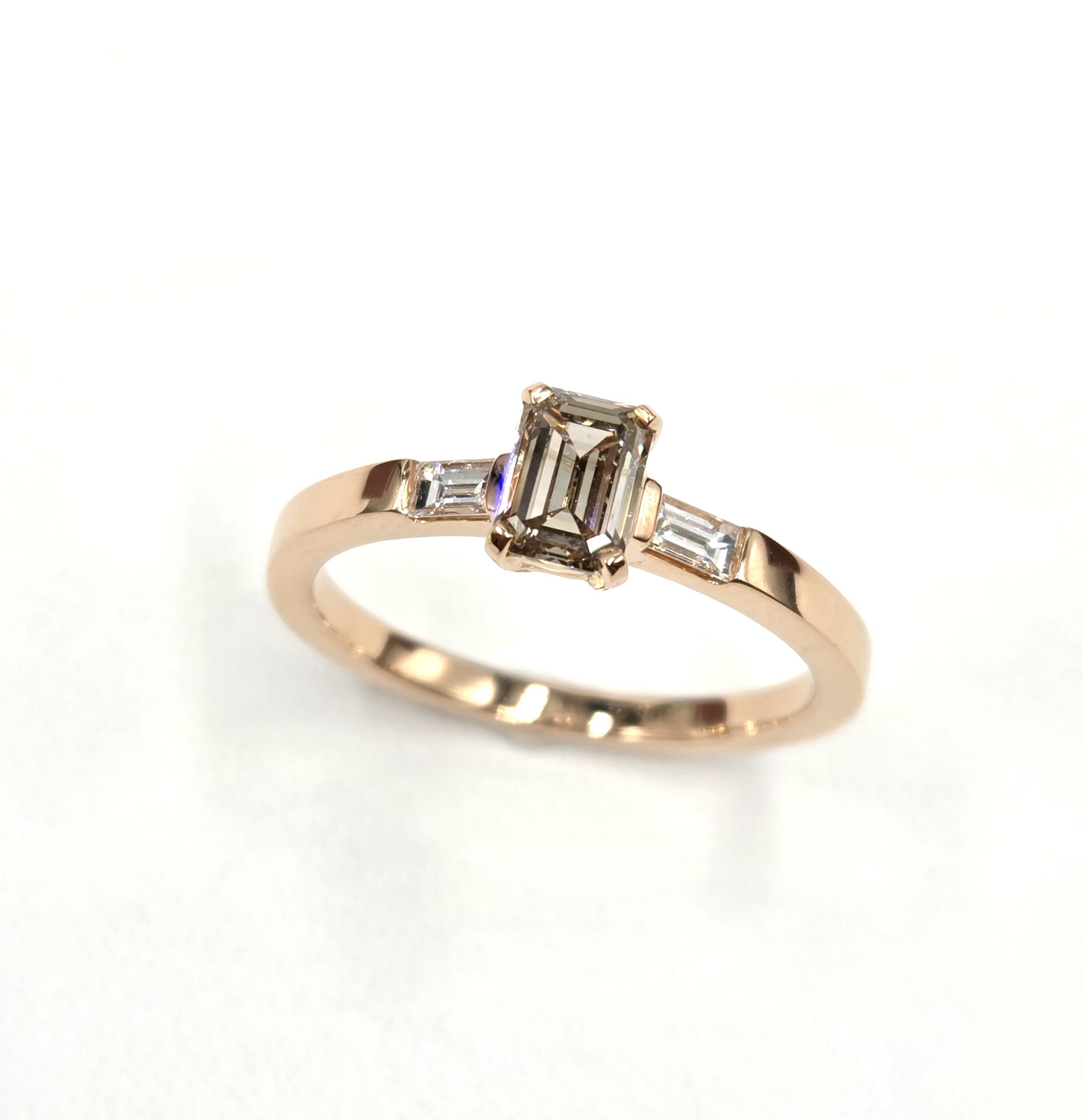bague de fiançailles en or rose composé d un diamant taille émeraude couleur cognac et de deux baguettes