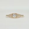Bague en or jaune avec diamant central serti clos et pavage de diamants sur gradins