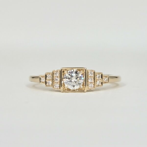 Bague en or jaune avec diamant central serti clos et pavage de diamants sur gradins