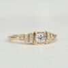 Bague en or jaune avec diamant central serti clos et pavage de diamants sur gradins