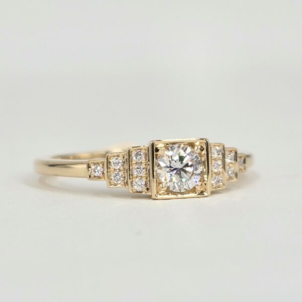 Bague en or jaune avec diamant central serti clos et pavage de diamants sur gradins