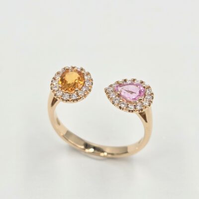 Bague ouverte en or rose avec deux saphirs de couleurs différentes sertis de diamants.