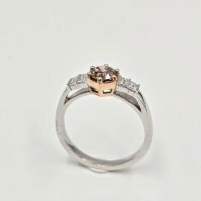 Bague en or blanc et rose avec diamant cognac rond et pavage de diamants baguettes.