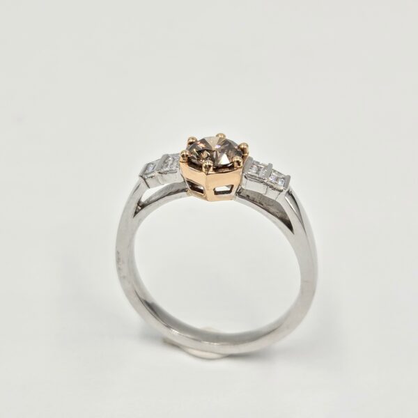 Bague en or blanc et rose avec diamant cognac rond et pavage de diamants baguettes.