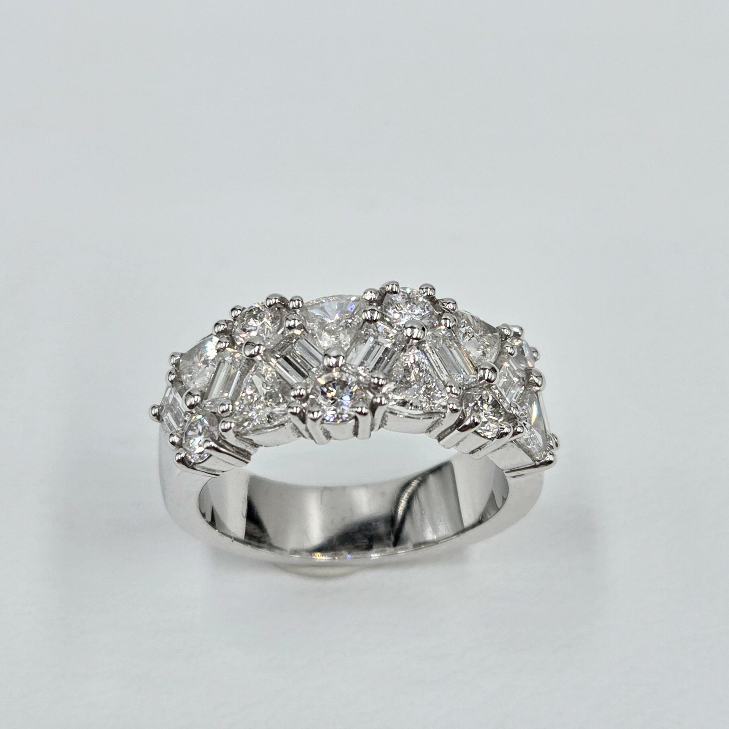 Bague bandeau en or blanc sertie de diamants taille brillant, baguette et triangle.