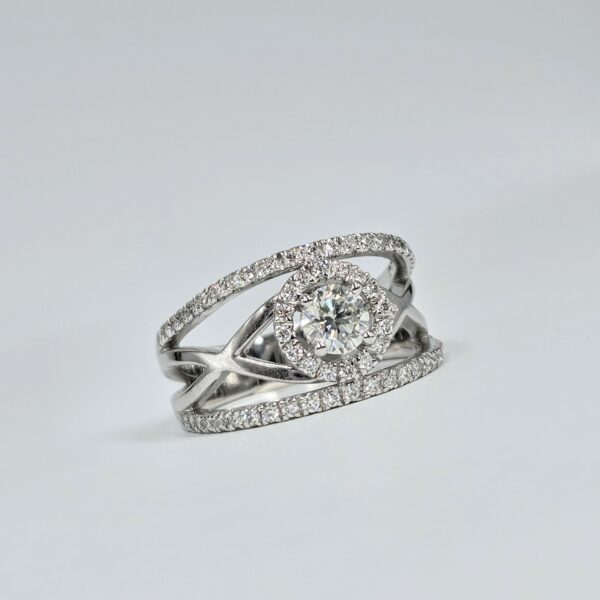 Bague en or blanc croisé avec halo de diamants et diamant central rond serti 4 griffes.