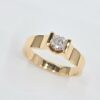 Bague en or jaune avec diamant central rond serti demi-clos
