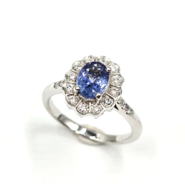 Bague en or blanc avec saphir ovale et halo de diamants, création française – vue studio fond blanc