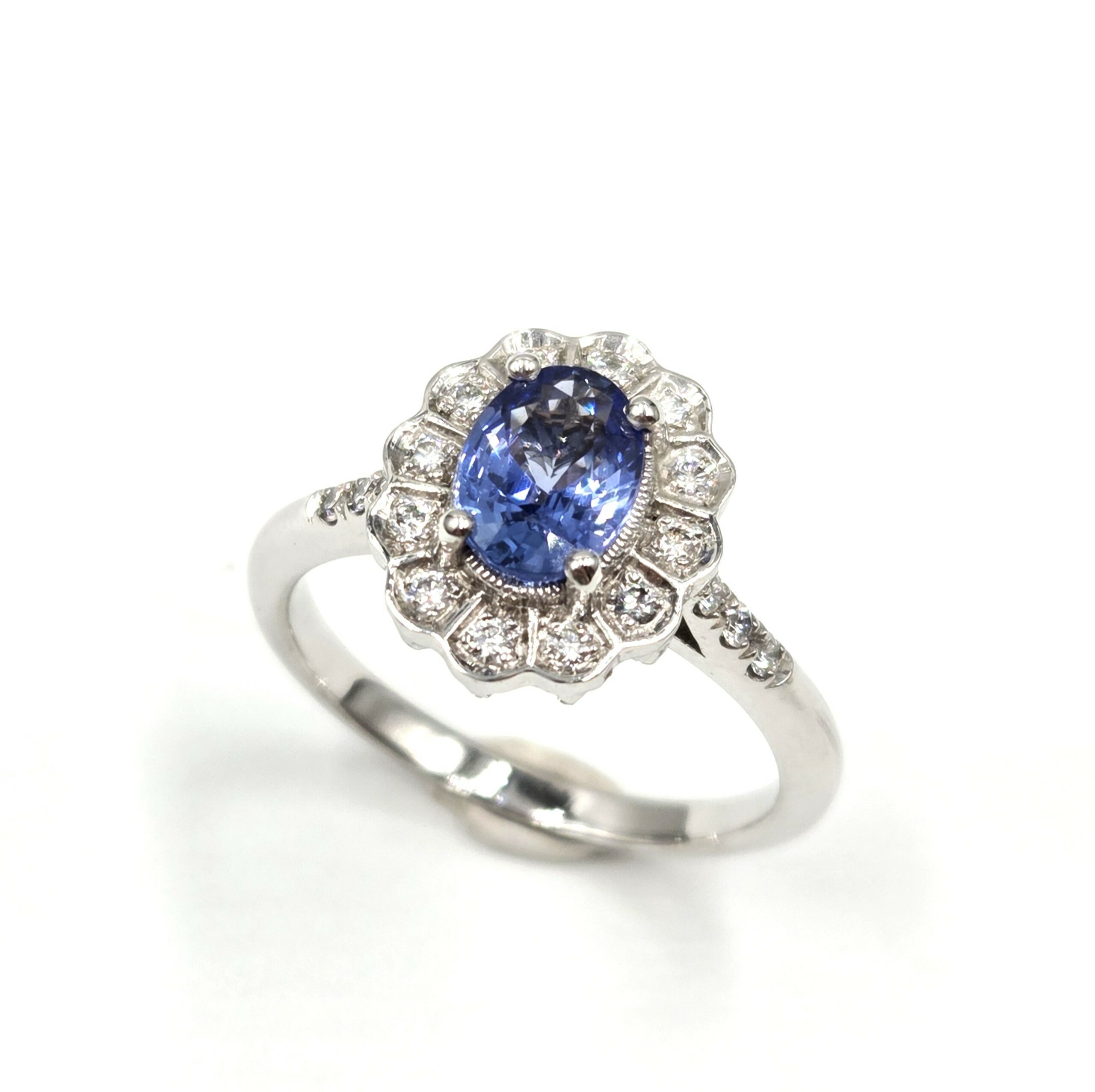 Bague en or blanc avec saphir ovale et halo de diamants, création française – vue studio fond blanc