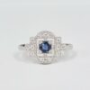Bague en or blanc palladié avec saphir bleu rond et pavage de diamants en forme art déco