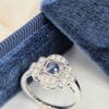 Bague en or blanc palladié avec saphir bleu rond et pavage de diamants en forme art déco