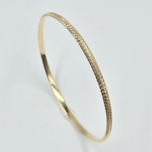 bracelet jonc rigide en or jaune 18 carats finition martelée et facettée, sans pierre