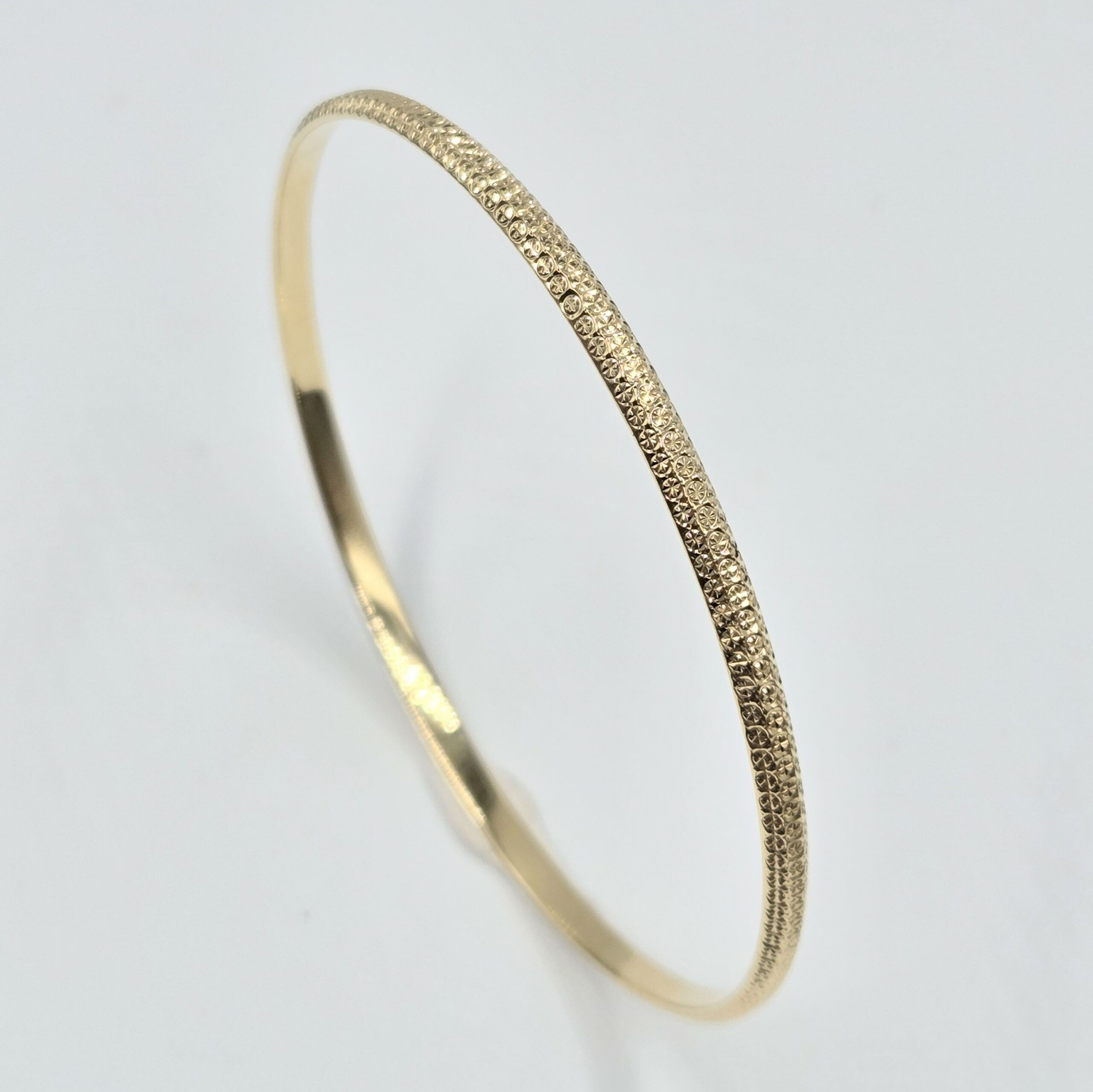 bracelet jonc rigide en or jaune 18 carats finition martelée et facettée, sans pierre