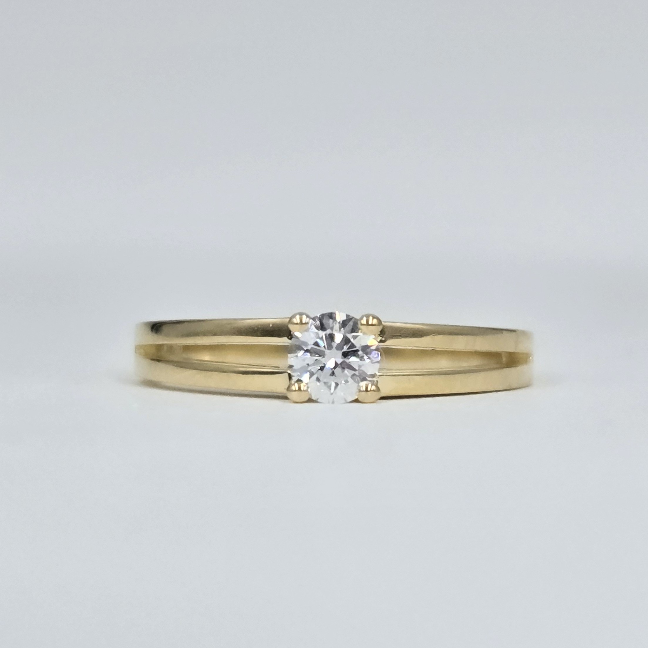 Solitaire en or jaune 18 carats avec diamant central taille brillant sur monture fendue